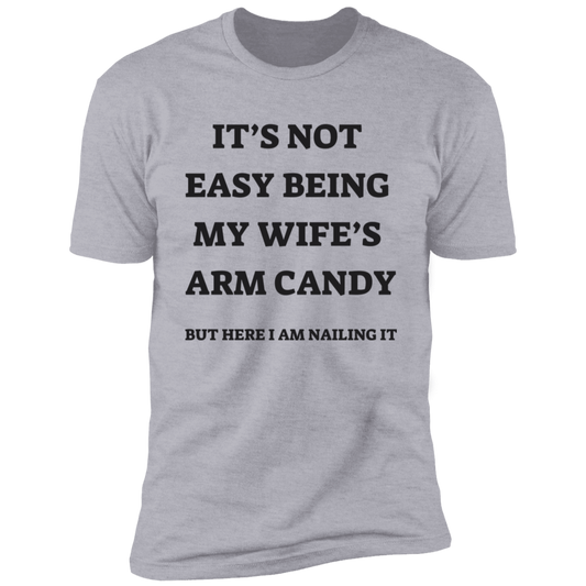 Gray short-sleeve t-shirt with message: It's not easy being my wife's arm candy but here I am nailing it.
