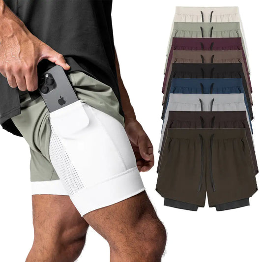 Picture of a man putting his cell phone in the side pocket of athletic shorts. Snug fit shorts on the inside and loose fitting jogging shorts on the outside with drawstring waist. Picture includes a stack of shorts in other colors: eggshell, olive, burgundy. sand, black, slate blue, slate gray. brown, and beige.