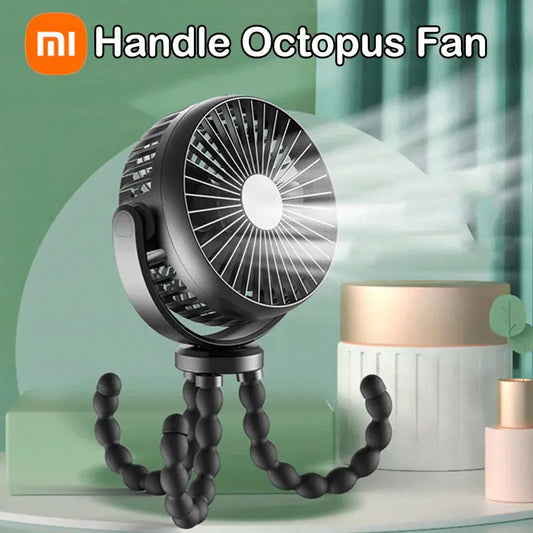 Small black fan with three bendable legs sitting on a desk top.