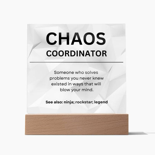 Square acrylic plaque describing a Chaos Coordinator. A crumpled paper background. Acrylic plaque in a wooden base.