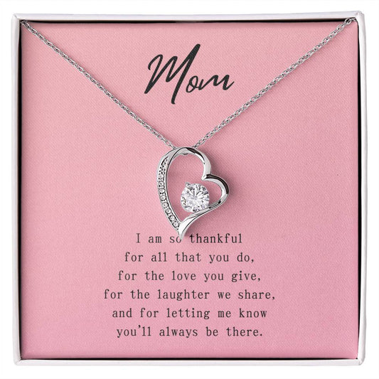 Pink message card with poem to Mom. Silver necklace with cubic zirconia heart-shaped pendant.